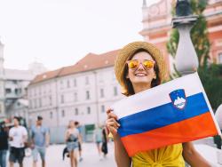 Žena drží slovinskou vlajku.