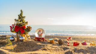 Malý vánoční stromek, dárky a sněžítko na pláži