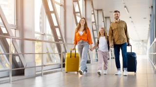 Rodina s dítětem jde letištní chodbouv