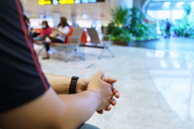 Cestující sedí v odletové hale letiště