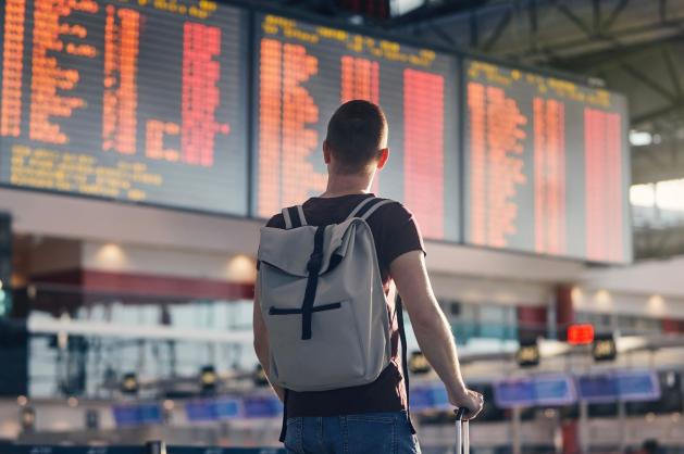 Cestující sleduje tabuli s odlety
