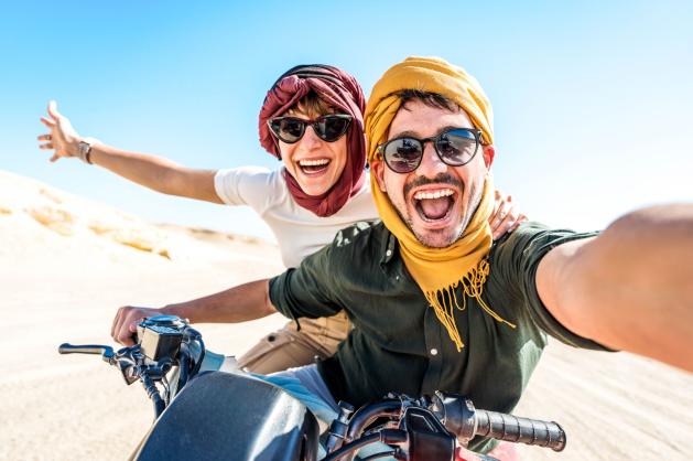 Usměvavý pár jedoucí na čtyřkolce.