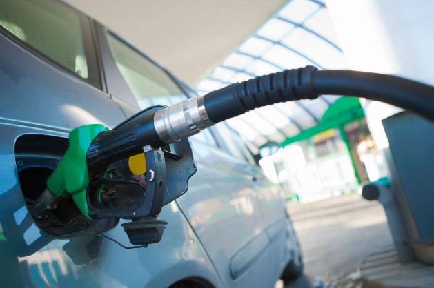 Detail tankovací pistole zasunuté do osobního automobilu 