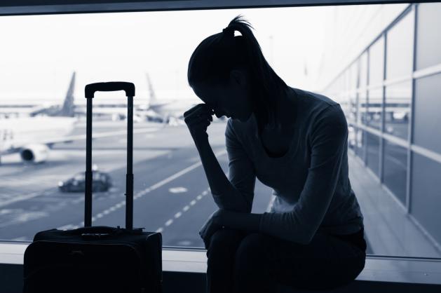 Cestující sedí u okna letištní haly