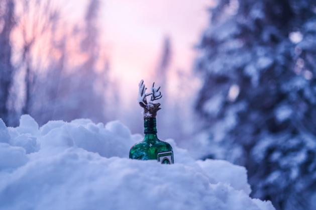 Láhev alkoholu zabodnutá ve sněhu
