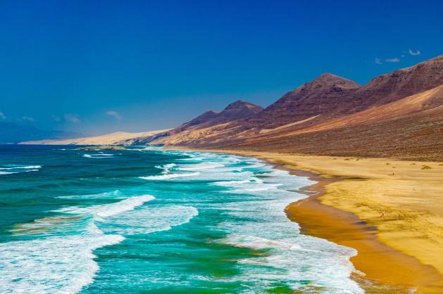 Divoká pláž s horami na západě ostrova