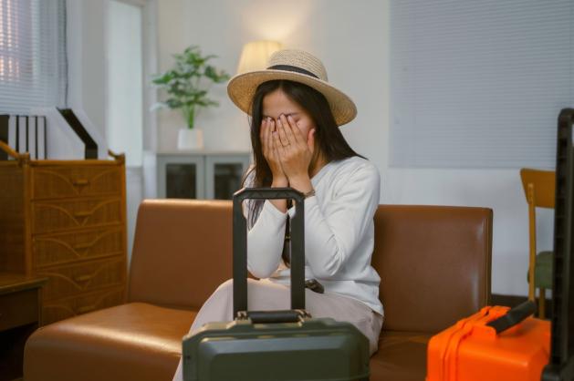 Cestovatelka sedí doma s kufrem