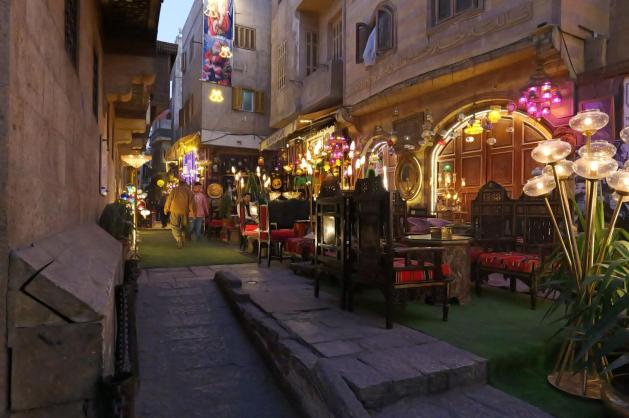 Osvětlená ulice s restauracemi a obchody