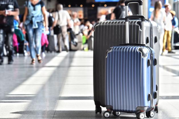 Cestovní kufry v rušném letištním terminálu