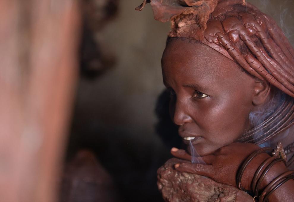 Detail ženy z kmene Himba při očistném kouřovém rituálu.