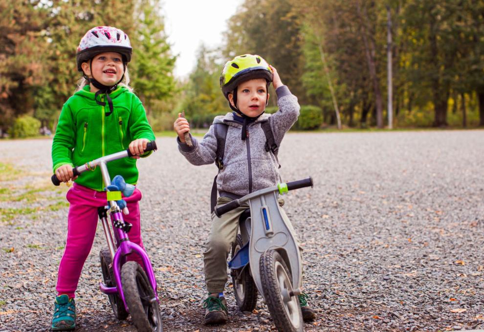 Děti v helmách na kole.