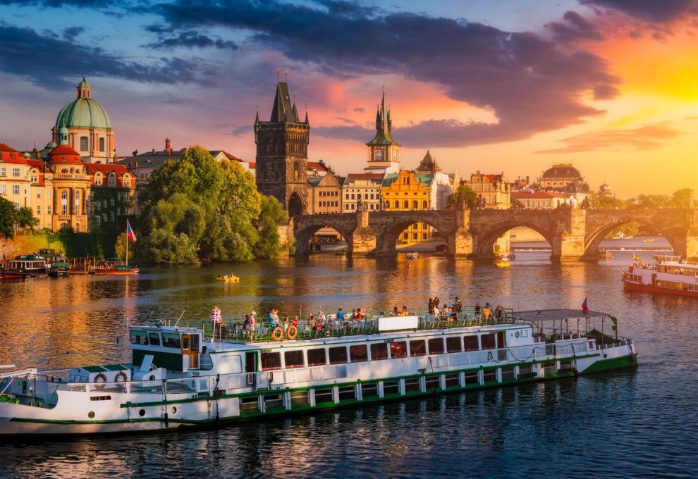 Loď plující po Vltavě s výhledem na Karlův most a Staré Město