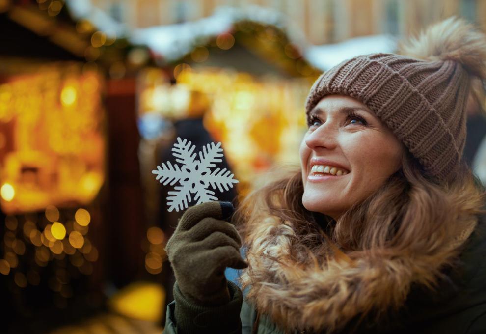 Usmívající se žena držící ozdobnou sněhovou vločku 