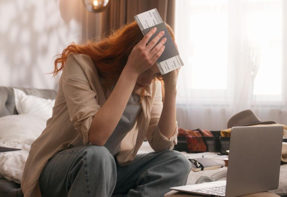 Žena s letenkou sedí u notebooku