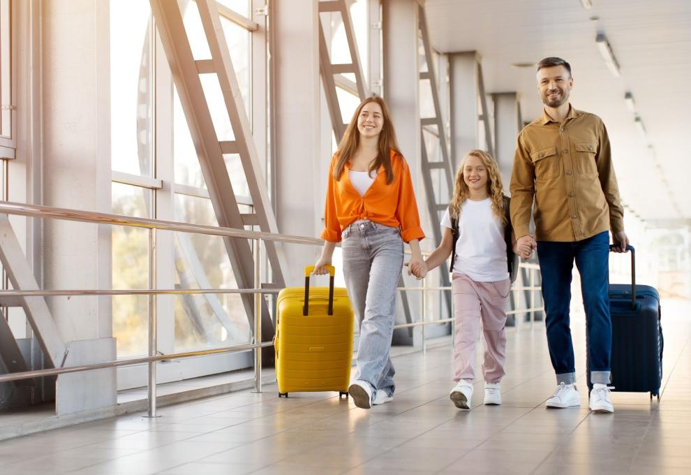Rodina s dítětem jde letištní chodbouv