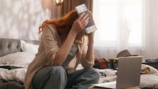 Žena s letenkou sedí u notebooku