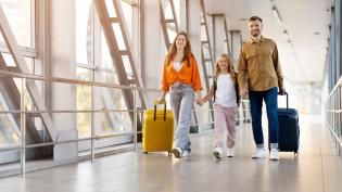 Rodina s dítětem jde letištní chodbouv