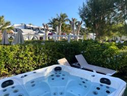 Soukromá vířivka obklopená zelení a lehátky 