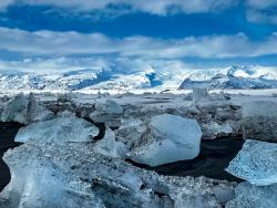 Ledové bloky a hory v pozadí