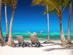 Žena na lehátku mezi palmami 