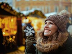 Usmívající se žena držící ozdobnou sněhovou vločku 