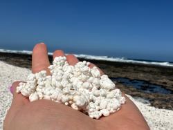 Bílé útvary připomínající popcorn na pláži