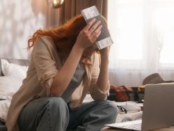 Žena s letenkou sedí u notebooku