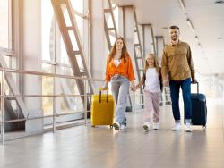 Rodina s dítětem jde letištní chodbouv