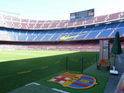 Logo týmu FC Barcelona v trávníku u laviček na fotbalovém stadionu Camp Nou. - Cestovinky.cz